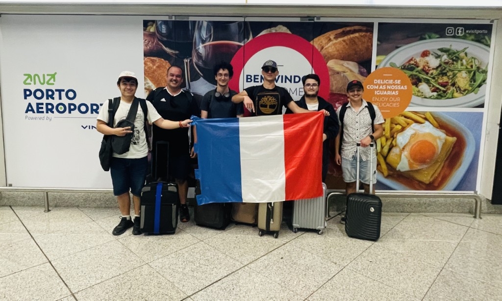 Groupe d'apprentis posant à l'aéroport de Porto avec un drapeau français